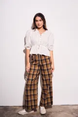 Pantalón de tiro medio, corte recto y pierna ancha, con estampado de cuadros escoceses en tonos marrón, beige y negro.