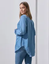 Camisa celeste de tencel, marca Hester & Orchand. Tiene cuello con solapa, escote en V, abertura central con botones, bolsillo aplicado en el frente y ruedo desflecado.