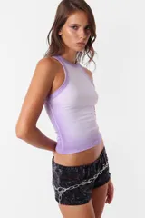 Top de morley color lila con cuello redondo y escote deportivo. Presenta collareta ancha en sisas y cuello, y un detalle de teñido sopleteado artesanal en costuras y terminaciones.