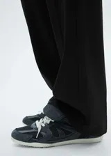 Pantalón de vestir de corte recto y diseño largo, confeccionado en tejido fluido con bolsillos laterales y cierre oculto de botón, gancho y cremallera.