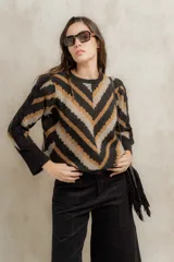 Sweater de punto jacquard con diseño de chevron en tonos negro, beige y marrón. Presenta cuello redondo, corte holgado y mangas largas con hombros abullonados.