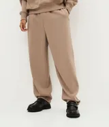 Pantalón de corte baggy confeccionado en algodón con felpa, color gris melange. Presenta cintura elástica con cordón ajustable, bolsillos laterales y bajo con regulador elástico.
