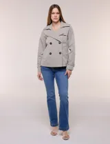 Gabardina corta gris, de silueta ligeramente entallada con diseño clásico de trench, cuello camisero con solapas amplias, cierre cruzado con doble botonadura y bolsillos laterales diagonales.