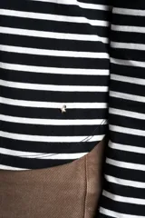 Remera de manga larga con diseño de rayas horizontales en blanco y negro, cuello redondo y corte ajustado al cuerpo.