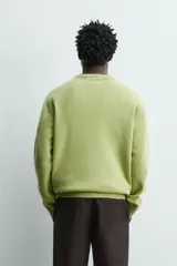 Sweater de punto relaxed fit confeccionado en hilatura con mezcla de lana y fibra de alpaca, de color verde, cuello redondo y manga larga, con acabados en rib.