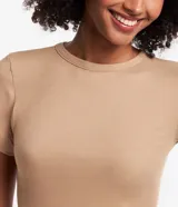 Blusa básica de manga corta y cuello redondo, confeccionada en viscosa texturizada con elastano, de corte ajustado y diseño con bajo ondulado.