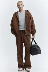 Campera con capucha H&M de corte oversized, confeccionada en tejido pesado de mezcla de algodón con interior cepillado. Presenta cierre frontal, hombros caídos, capucha forrada con cordón de ajuste y bolsillos tipo canguro. Puños y bajo acanalados.