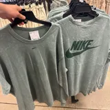 Remera de manga larga Nike con efecto lavado, cuello redondo y pequeño logo bordado en el centro del pecho.