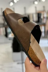 Sandalia marrón con diseño de dos tiras ajustables con hebillas metálicas y plantilla anatómica.