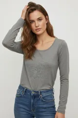 Remera blanca de manga larga, de algodón y elastano, corte ajustado y cuello redondo.