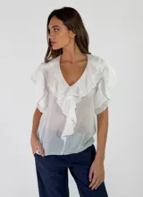 Blusa de algodón color blanco, con cuello en V y detalles de volados en el frente y mangas cortas.