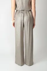 Pantalón de pierna amplia color plateado con acabado metalizado, cintura elástica fruncida y bolsillos laterales.