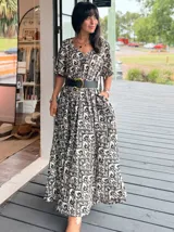 Vestido largo de corte amplio con estampado floral en tonos turquesa, blanco y rosa. Posee escote en V, mangas cortas y espalda con lazo.