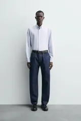 Camisa de corte regular fit confeccionada en popelín de algodón. Presenta cuello abotonado, manga larga con puños ajustables mediante botón y cierre frontal de botonadura completa.