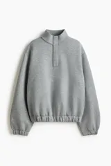 Buzo de corte holgado en tejido con efecto neopreno, con hombros caídos, cuello elevado y tapeta frontal con botones a presión ocultos. Presenta puños y bajo con elástico revestido.