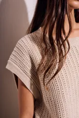 Chaleco sin mangas de tejido de punto color rosado pálido, con textura calada y acabado lurex, corte al cuerpo y cuello redondo.