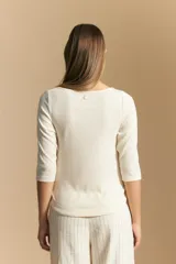 Remera de tejido acanalado (rib) color blanco, con escote cuadrado y mangas tres cuartos, de ajuste entallado al cuerpo.