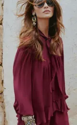 Blusa color borgoña con cuello alto con lazo, mangas 3/4 abullonadas y peplum.