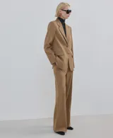 Pantalon de vestir color tostado, de corte recto y tiro medio, con bolsillos laterales y cierre frontal.
