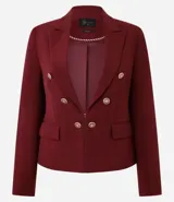 Blazer de sastrería color bordó, de corte slim, con solapas clásicas, cierre frontal cruzado con botones dorados y bolsillos laterales con solapa.