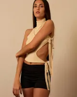 Top color crema con cuello alto, espalda descubierta y lazos ajustables.