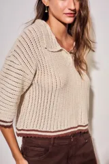 Sweater de tejido abierto de algodón, color beige, con cuello polo, mangas cortas y detalles en color marrón oscuro en los bordes y puños.