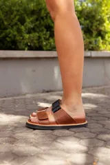 Sandalias de cuero color marrón con dos tiras ajustables, una de cuero liso y otra con textura de cocodrilo en color negro.