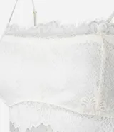 Blusa cropped de encaje color blanco, con escote recto, breteles finos y forro.