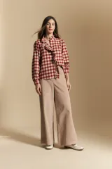 Camisa de algodón a cuadros con diseño de volados frontales, cuello alto y mangas largas con leve volumen.