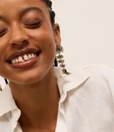 Caravanas maxi de metal con diseño de pez articulado y acabado martillado en color dorado.