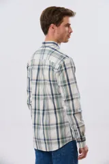 Camisa de manga larga de calce slim, con diseño a cuadros en tonos azul oscuro, verde y blanco. Presenta cuello camisero con botones y bolsillo ojal en el pecho con detalle bordado.
