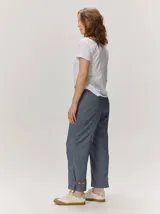 Pantalón de lino color blanco crudo, de corte barrel, con bolsillos laterales y costuras pespunteadas a contratono.