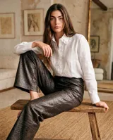 Camisa blanca de lino 100% natural, de manga larga, con cuello bobo amplio y detalles de puntilla en el cuello y la cartera de botones.