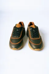 Championes de cuero en combinación de colores verde oliva y detalles en cuero color suela. Presentan cordones al tono y una suela de goma robusta en color suela con diseño dentado.