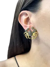 Aros dorados con forma de cangrejo, incrustaciones de circonitas rosas y ojos negros.