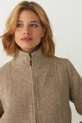 Campera de lana fina sin teñir, con cuello alto, cierre frontal completo y diseño de corte recto con pespuntes decorativos en puños, ruedo y cuello.