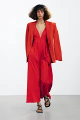 Vestido largo rojo de Zara Woman Collection confeccionado en hilatura con mezcla de algodón. Escote pico y tirantes finos cruzados en la espalda ajustable con lazadas. Tiene bolsillos laterales, detalle de pliegues en la cintura y cierre en la espalda con cremallera oculta en la costura.