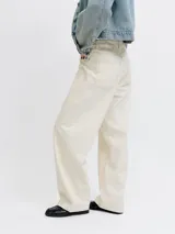 Jeans baggy de tiro bajo en color marfil, con diseño de pernera ancha y costuras pespunteadas a contratono.
