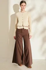 Pantalón de lino blanco de corte wide leg, con diseño amplio y costuras pespunteadas a contratono.