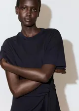Vestido corto negro de manga corta y cuello redondo, con detalle de lazo cruzado en la cintura.