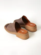 Sandalias marrones de cuero texturizado con diseño de tira ancha en el empeine y separación para el dedo, taco cuadrado bajo y suela plataforma.