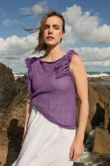 Musculosa tejida en punto calado, color violeta, con diseño sin mangas y detalle de flecos en los hombros.