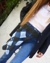 Vestido midi tejido a mano en crochet color celeste, con diseño de falda asimétrica y detalle de faja ajustable en contraste color gris oscuro con patrón de damero.