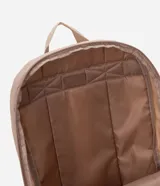 Mochila femenina color beige con textura acolchada y bolsillo frontal con cierre. Incluye asas largas ajustables, correa de mano y llavero de pompón.