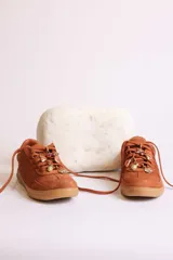 Zapatillas bajas color marrón con cordones y charms dorados.