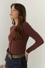 Remera color beige de mangas largas con cuello redondo y puños blancos en contraste.