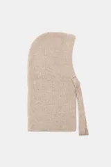Capucha de punto canalé en color beige, con diseño envolvente y cierre frontal ajustable mediante lazada a tono.