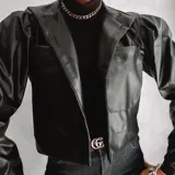 Campera corta negra de cuero sintético, con cuello tipo blazer, mangas abullonadas y bolsillos frontales.