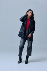 Blazer de eco cuero negro con cuello de solapa, cierre frontal con botones y bolsillos aplicados en la parte delantera. Cuenta con forro interno a tono.