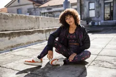 Calza larga negra con estampado abstracto en tonos rosa y rojo.